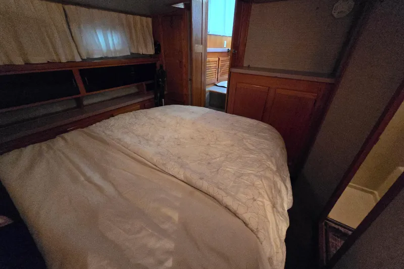 Slide: The Image of Cozy cabin interior of 1988 Mainship 36 Double Cabin with bed and wooden storage. - 25