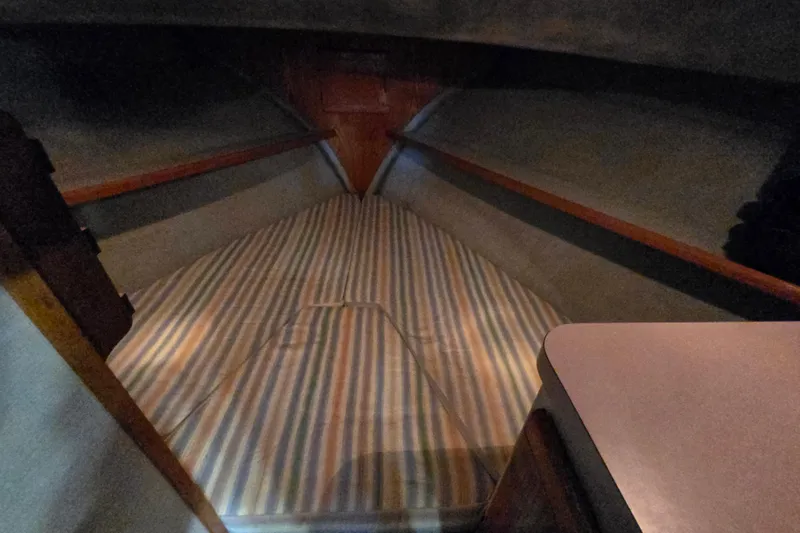 Slide: The Image of 1988 Mainship 36 Double Cabin interior with striped bedding and wooden accents. - 28