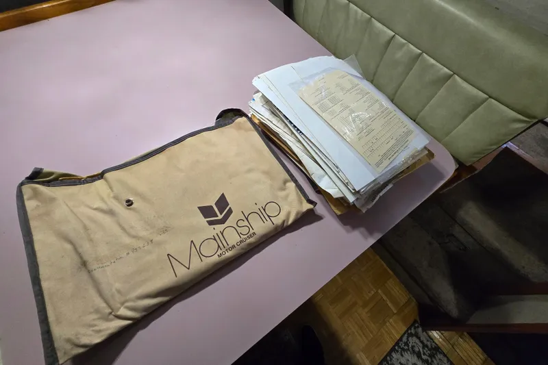 Slide: The Image of Mainship 36 Double Cabin 1988 documents and manual on a table. - 29