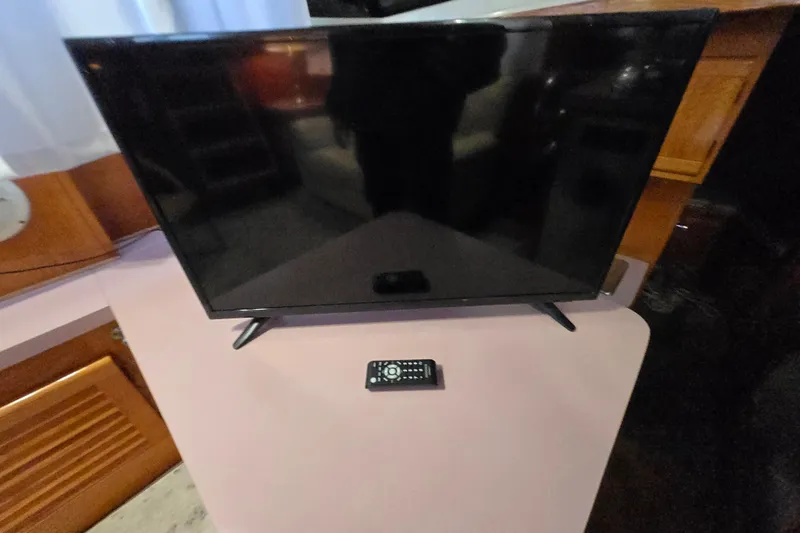 Slide: The Image of Flat-screen TV with remote on a Mainship 36 Double Cabin, 1988 model. - 36