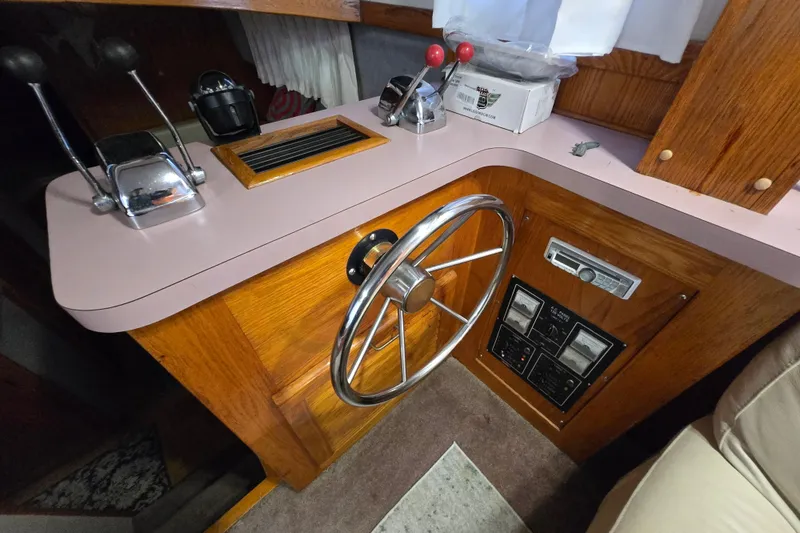 Slide: The Image of 1988 Mainship 36 Double Cabin helm with steering wheel and control levers. - 37