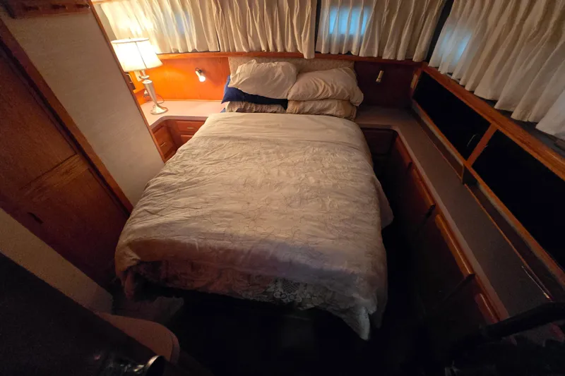 Slide: The Image of Cozy bedroom in 1988 Mainship 36 Double Cabin with warm lighting and wood accents. - 5