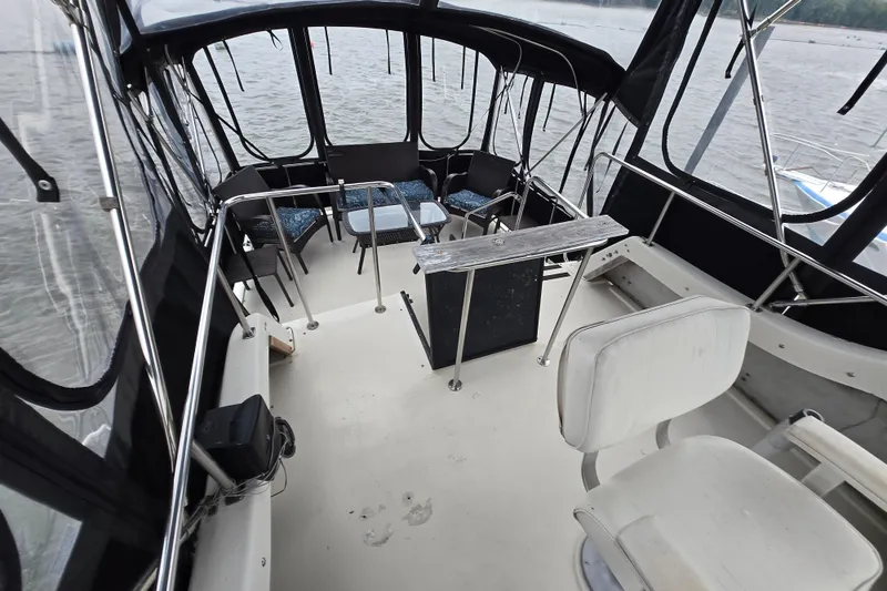 Slide: The Image of 1988 Mainship 36 Double Cabin interior with seating and helm, overlooking water. - 7
