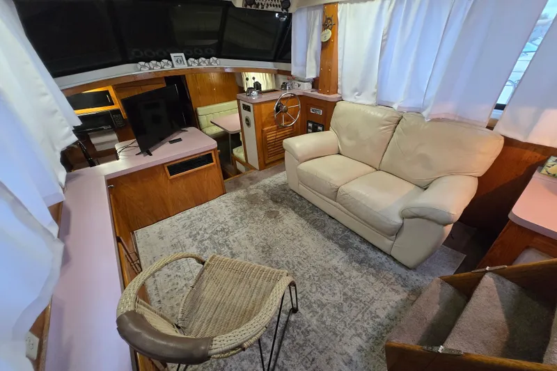 Slide: The Image of Interior of 1988 Mainship 36 Double Cabin with sofa, helm, and TV setup. - 8