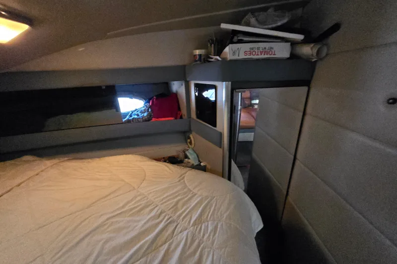 Slide: The Image of Cozy cabin interior of 1988 Bayliner 3450 Avanti with a comfortable bed setup. - 13