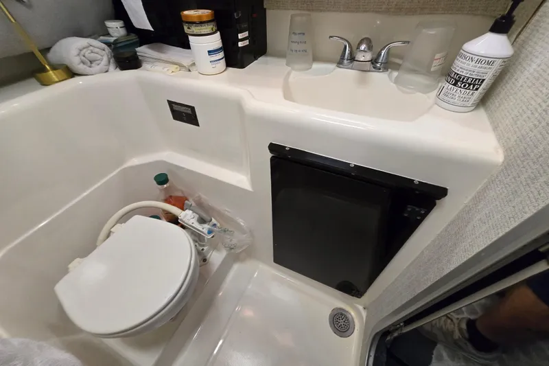 Slide: The Image of Compact bathroom in 1988 Bayliner 3450 Avanti boat with sink, toilet, and towels. - 23