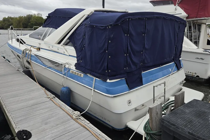 Slide: The Image of 1988 Bayliner 3450 Avanti docked with blue canvas cover. - 50