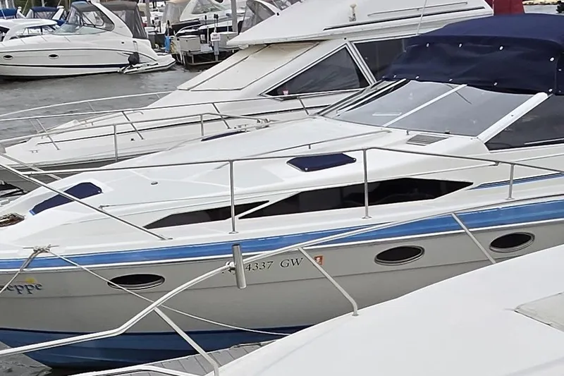 Slide: The Image of 1988 Bayliner 3450 Avanti docked among other boats at a marina. - 51