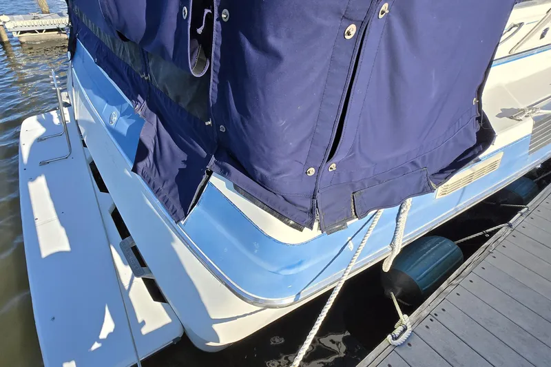 Slide: The Image of 1988 Bayliner 3450 Avanti boat with blue cover docked at marina. - 9