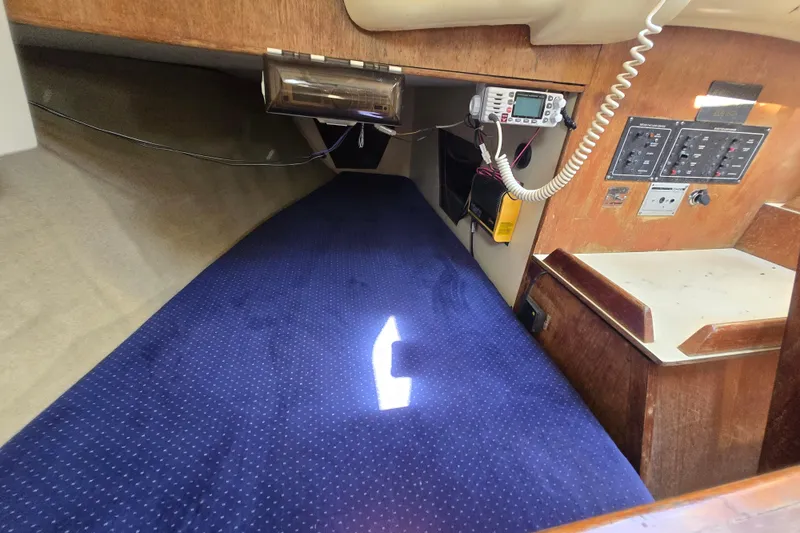 Slide: The Image of Interior of 1986 Pearson 303 Sloop with blue bedding and control panels. - 12