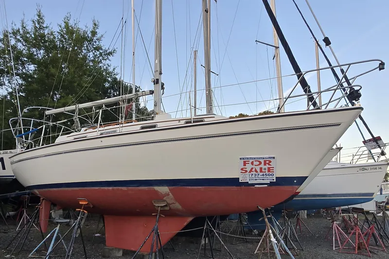 Slide: The Image of 1986 Pearson 303 Sloop sailboat for sale, displayed on stands in a boatyard. - 18