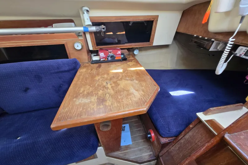 Slide: The Image of Interior of 1986 Pearson 303 Sloop with wooden table and blue seating. - 20