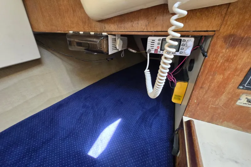 Slide: The Image of Interior of a 1986 Pearson 303 Sloop with communication equipment and blue carpet. - 22