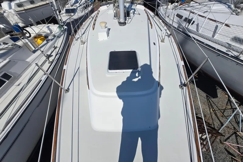 Slide: The Image of 1986 Pearson 303 Sloop deck with shadow, docked among other boats. - 7