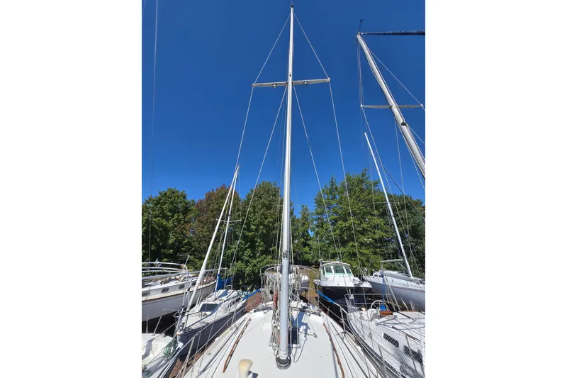 Slide: The Image of 1986 Pearson 303 Sloop sailboat with tall mast against clear blue sky. - 8