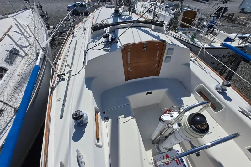 Slide: The Image of 1986 Pearson 303 Sloop sailboat cockpit with steering wheel and winches, docked in a marina. - 2