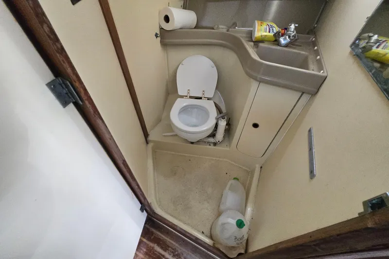 Slide: The Image of Compact bathroom in a 1986 Pearson 303 Sloop sailboat with toilet and sink. - 23