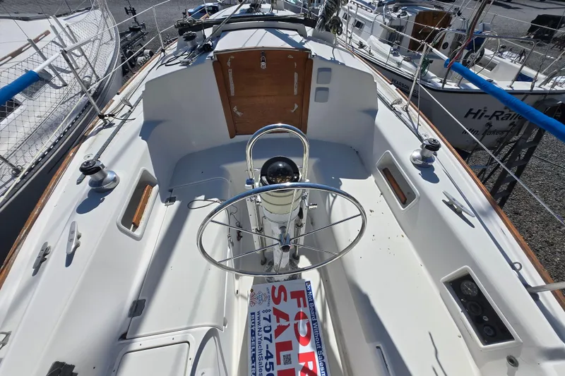 Slide: The Image of 1986 Pearson 303 Sloop cockpit with steering wheel, for sale sign visible. - 29