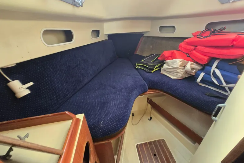 Slide: The Image of Interior cabin of 1986 Pearson 303 Sloop with blue seating and life jackets. - 3