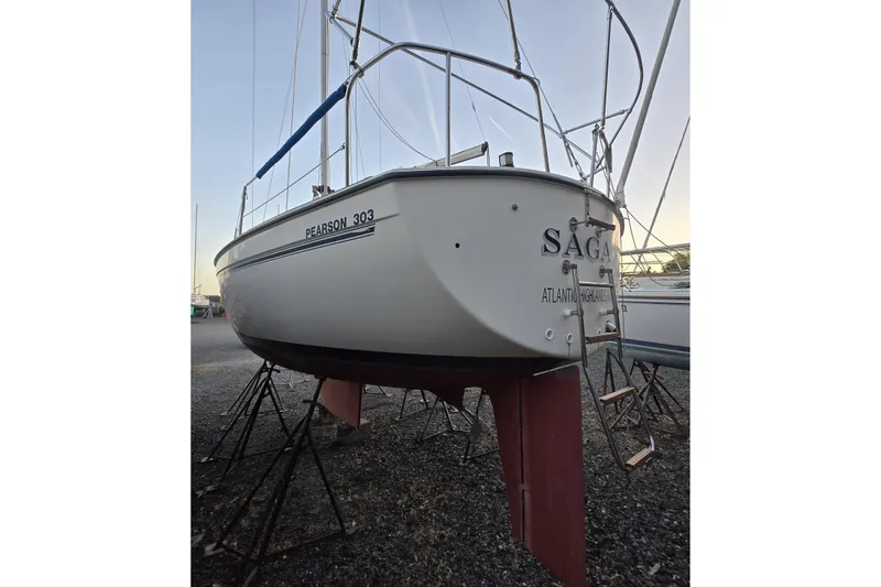 Slide: The Image of 1986 Pearson 303 Sloop sailboat on stands, rear view, with ladder and name "SAGA." - 6