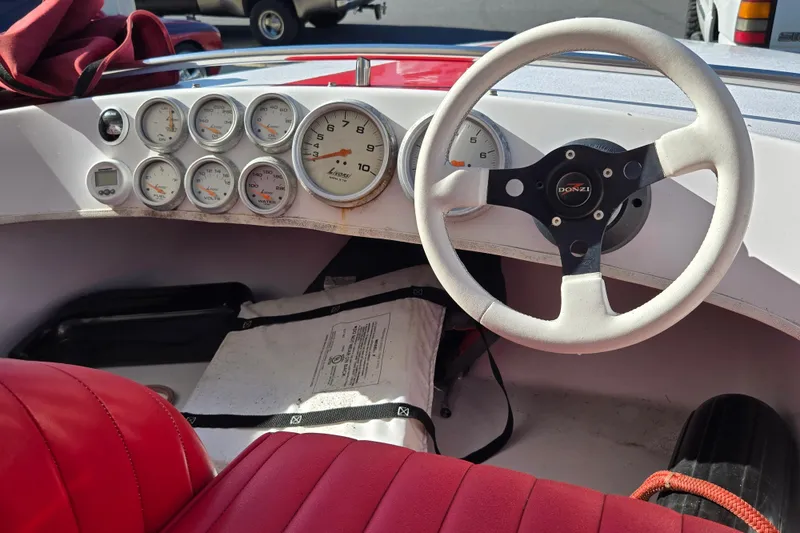 Slide: The Image of 2005 Donzi 16 Classic boat dashboard with gauges and red seating. - 5