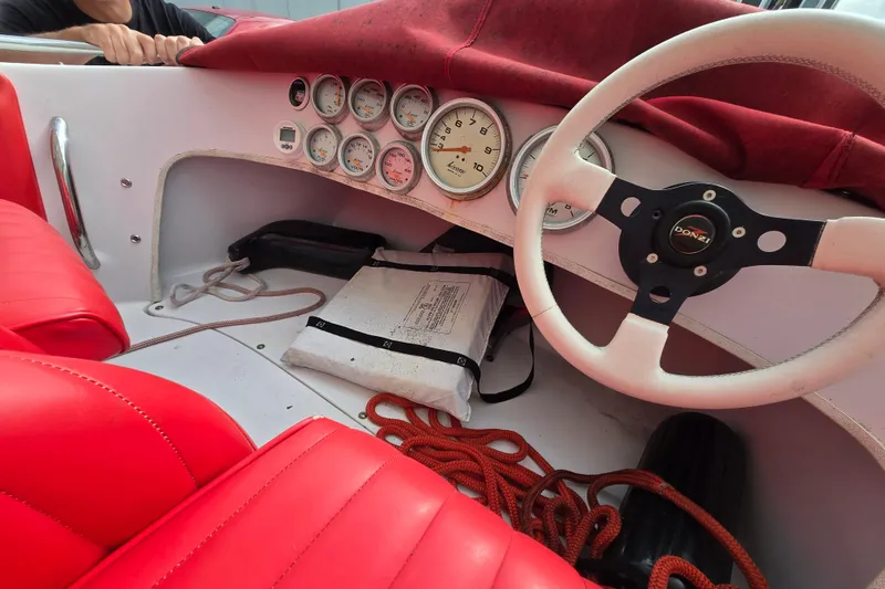 Slide: The Image of 2005 Donzi 16 Classic boat interior with red seats, steering wheel, and dashboard gauges. - 6