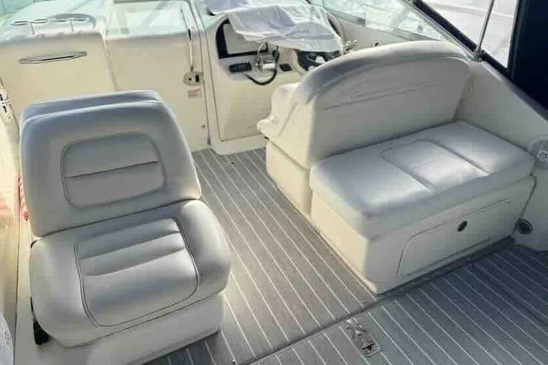 Slide: The Image of 2005 Sea Ray 290 Amberjack interior with white seating and steering console. - 15