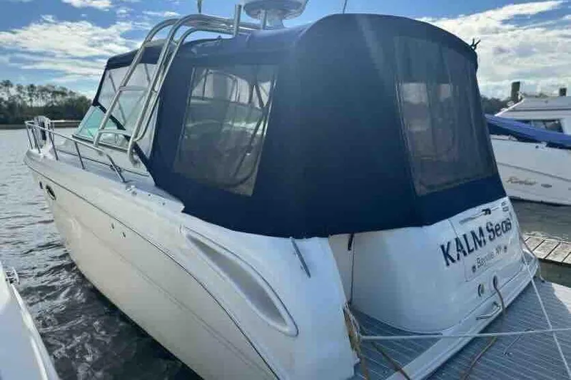 Slide: The Image of 2005 Sea Ray 290 Amberjack boat docked with blue canopy, rear view. - 16