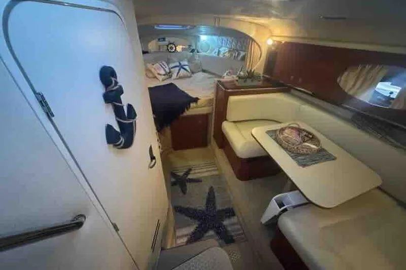 Slide: The Image of Interior of 2005 Sea Ray 290 Amberjack boat with cozy seating and nautical decor. - 17