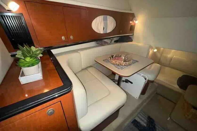 Slide: The Image of Interior of 2005 Sea Ray 290 Amberjack with cozy seating and wooden cabinetry. - 19