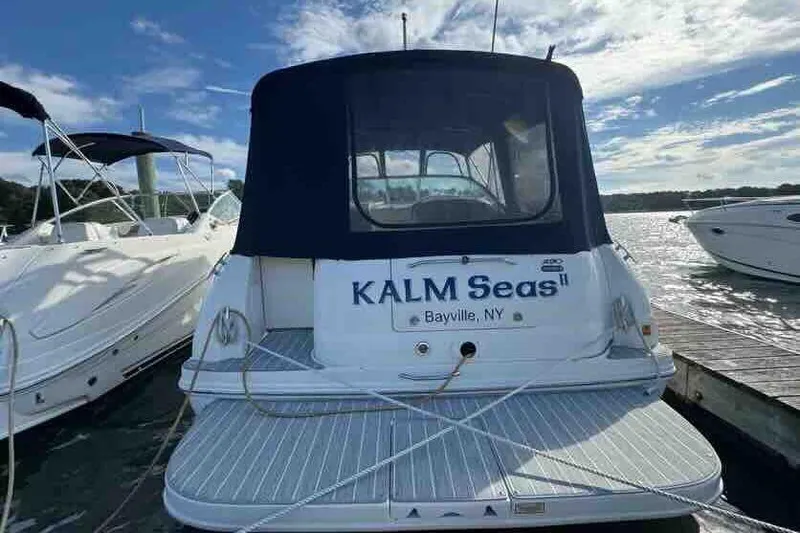 Slide: The Image of 2005 Sea Ray 290 Amberjack boat docked, rear view with "KALM Seas II" name. - 2