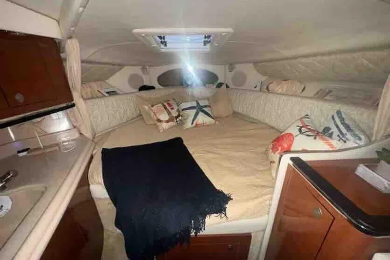 Slide: The Image of 2005 Sea Ray 290 Amberjack cabin interior with cozy bed and nautical decor. - 22