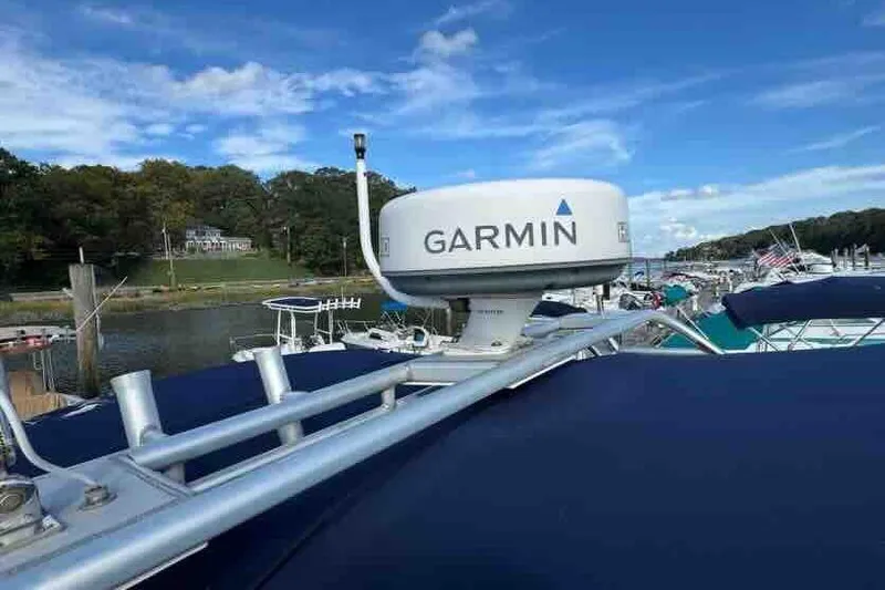 Slide: The Image of 2005 Sea Ray 290 Amberjack with Garmin radar, docked under a clear blue sky. - 6
