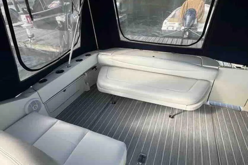Slide: The Image of Interior of 2005 Sea Ray 290 Amberjack boat with white seating and striped flooring. - 7