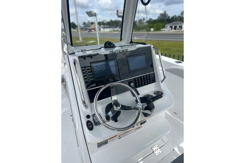 Slide: The Image of 2025 Hurricane Center Console 24 OB boat dashboard with steering wheel and digital displays. - 14