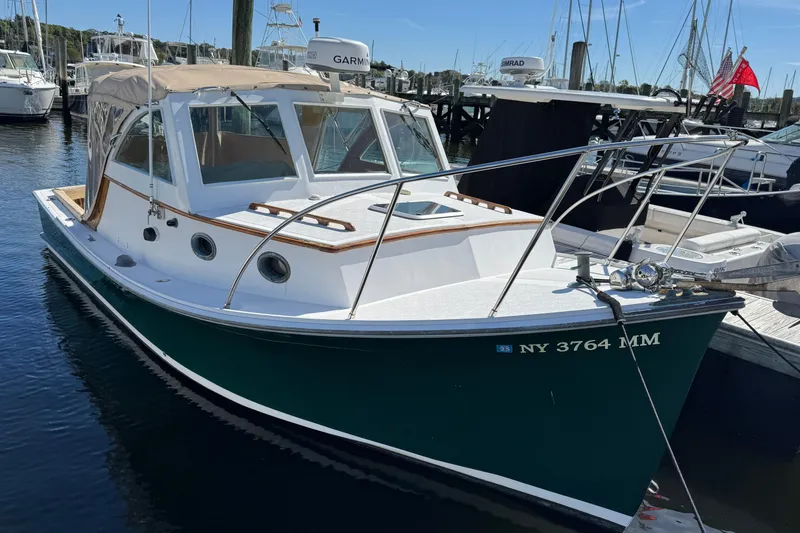 The Image of 1997 Webbers Cove PB 26 boat docked in marina, featuring sleek design and white hull. - 0