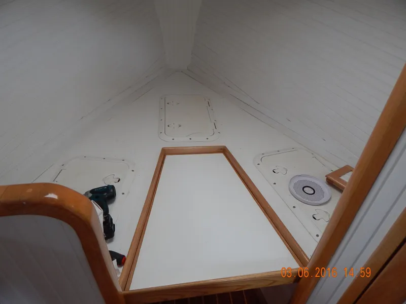 Slide: The Image of Interior cabin of a 1997 Webbers Cove PB 26 boat, featuring wooden trim and storage compartments. - 10
