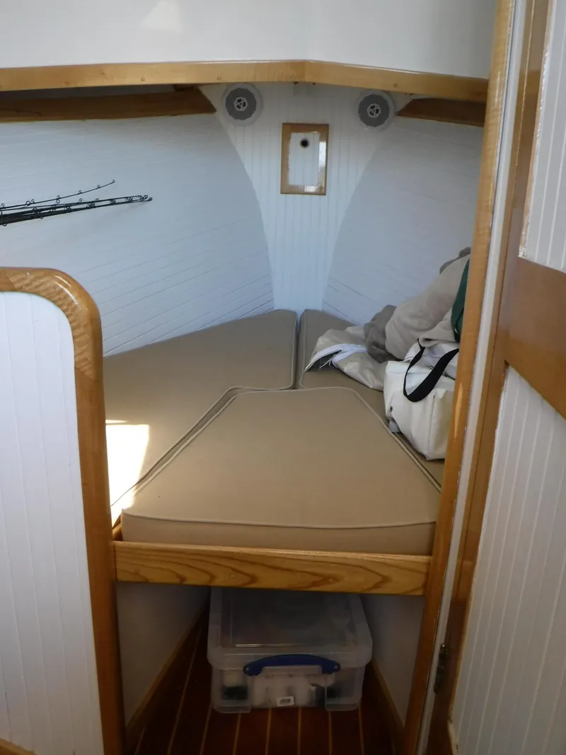 Slide: The Image of 1997 Webbers Cove PB 26 cabin interior with beige cushions and wooden accents. - 11