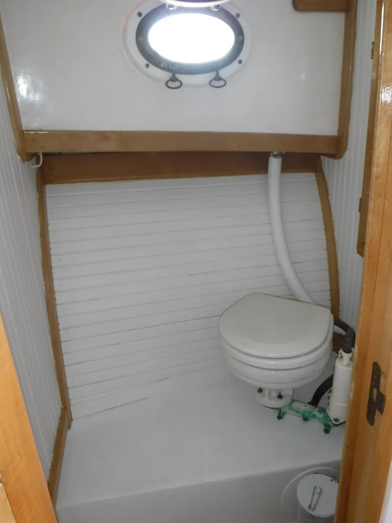Slide: The Image of Compact marine bathroom in 1997 Webbers Cove PB 26 boat with porthole and toilet. - 15