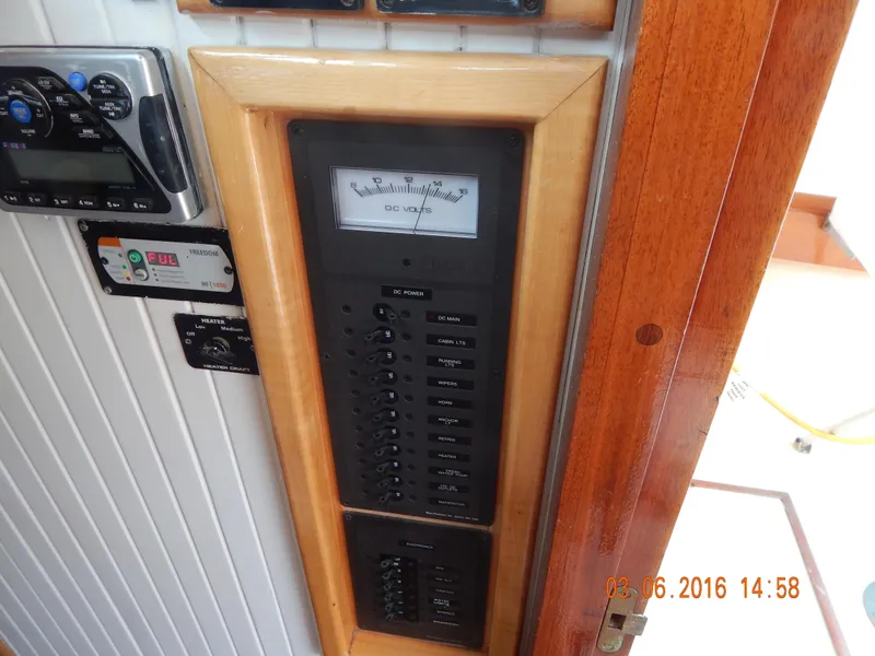 Slide: The Image of Electrical panel on a 1997 Webbers Cove PB 26 boat, featuring various switches and gauges. - 16