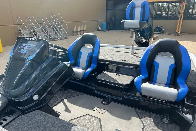 Slide: The Image of 2026 Nitro Z21 XL Pro boat with blue and gray seating, parked outdoors. - 84