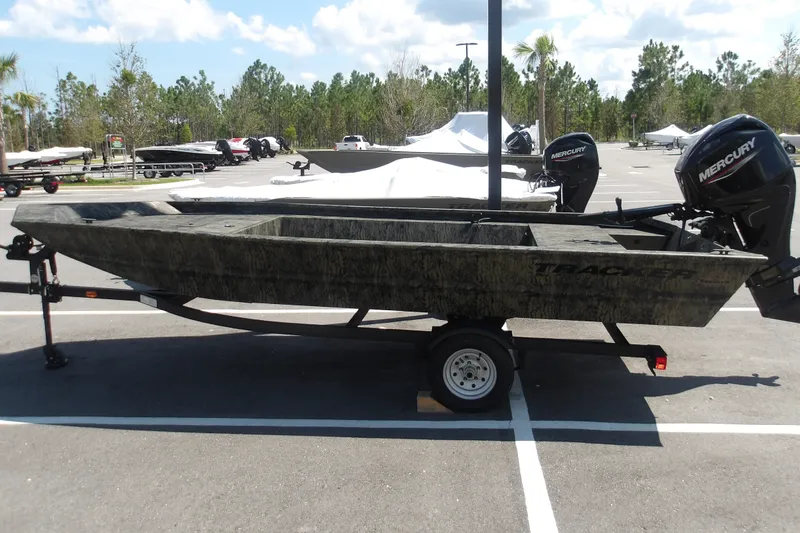 The Image of 2026 Tracker Grizzly 1754 Utility boat on trailer, parked outdoors under clear sky. - 0