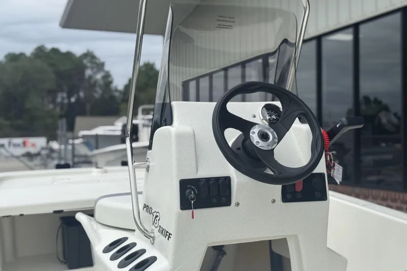 Slide: The Image of 2026 Mako Pro Skiff 13 CC boat console with steering wheel and controls. - 48
