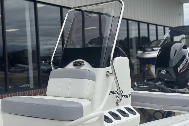 Slide: The Image of 2026 Mako Pro Skiff 13 CC boat with console and seating, displayed outdoors. - 50