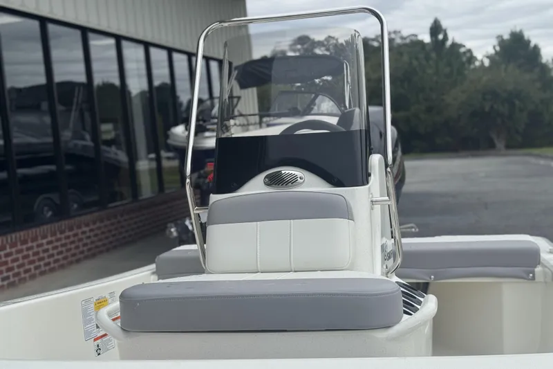 Slide: The Image of 2026 Mako Pro Skiff 13 CC boat with console and seating, parked outdoors. - 51