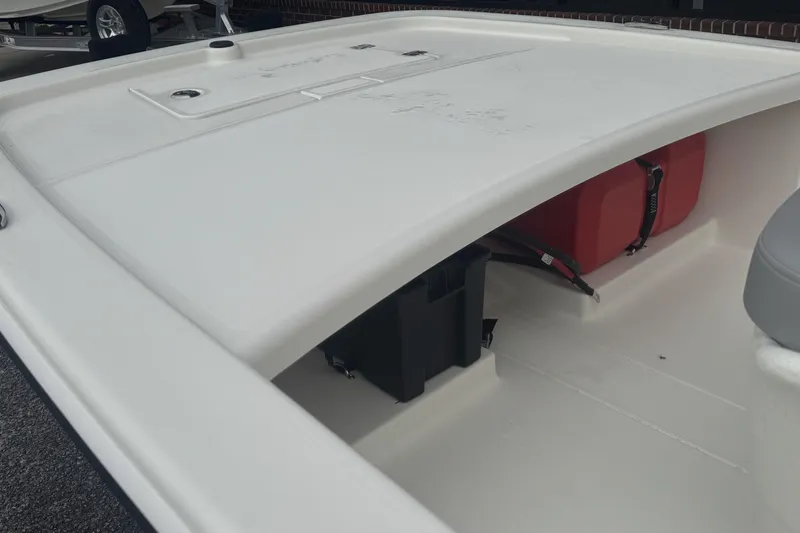 Slide: The Image of 2026 Mako Pro Skiff 13 CC boat interior with storage compartment and red fuel tank. - 53