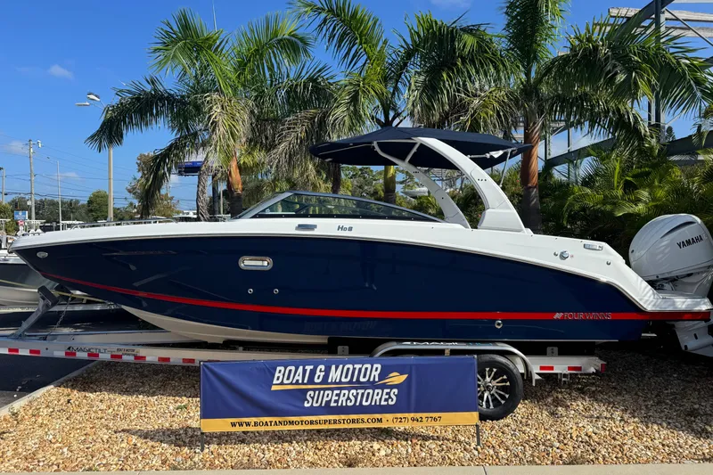Slide: The Image of 2026 Four Winns HD8 OB boat displayed at dealership, surrounded by palm trees. - 10