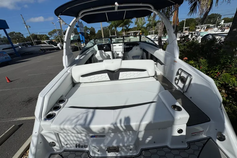 Slide: The Image of 2026 Four Winns HD8 OB boat with spacious seating and sleek design in a sunny marina. - 18