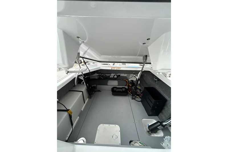 Slide: The Image of 2026 Four Winns H9 OB boat interior storage compartment with open hatch and visible wiring. - 14