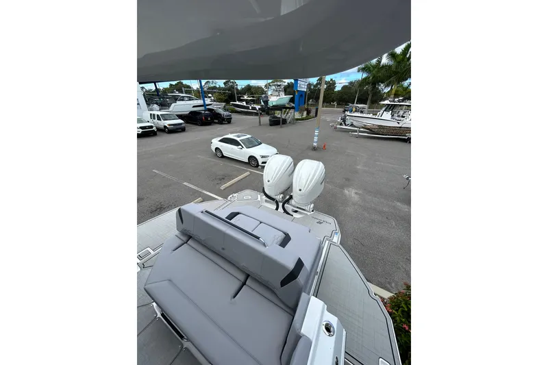 Slide: The Image of 2026 Four Winns H9 OB boat with dual outboard motors in a parking lot. - 15